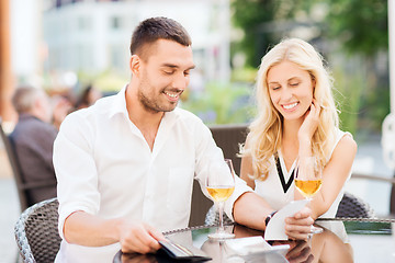 Image showing happy couple with wallet and bill at restaurant