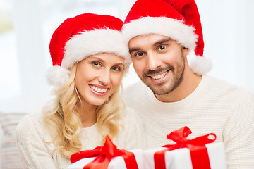 Image showing happy couple at home with christmas gift boxes