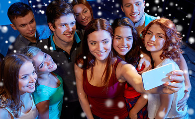 Image showing friends with smartphone taking selfie in club