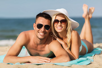 Image showing happy couple in swimwear lying on summer beach