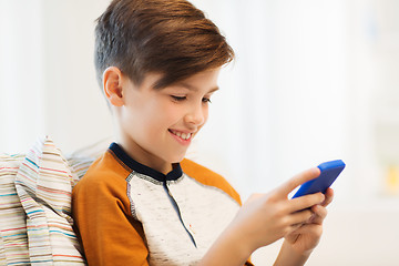 Image showing boy with smartphone texting or playing at home