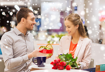 Image showing happy couple with present and flowers in mall