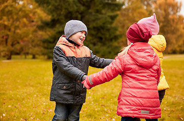 Image showing children holding hands and playing in autumn park