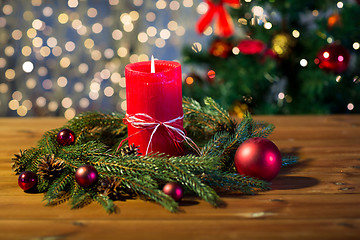 Image showing fir branch wreath with candle on wooden table