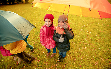 Image showing happy children with umbrella in autumn park