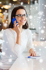 Image showing smiling woman calling on smartphone at cafe