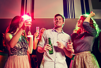 Image showing smiling friends with wine glasses and beer in club