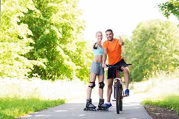 Image showing couple on rollerblades and bike showing thumbs up