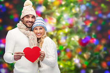 Image showing smiling couple in winter clothes with red hearts