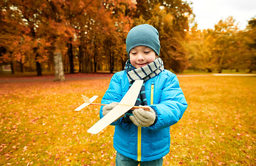 Image showing happy little boy playing with toy plane outdoors