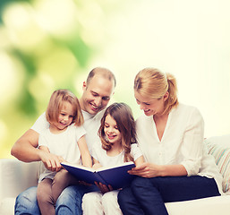 Image showing happy family with book at home