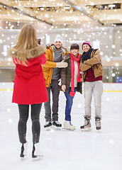 Image showing happy friends taking photo on skating rink