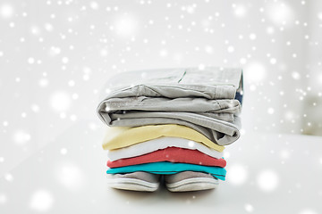 Image showing close up of folded shirts and boots on table