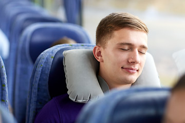 Image showing happy young man sleeping in travel bus with pillow