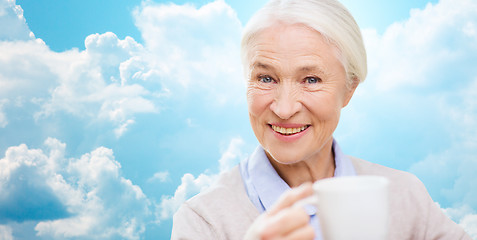 Image showing happy senior woman with cup of tea or coffee