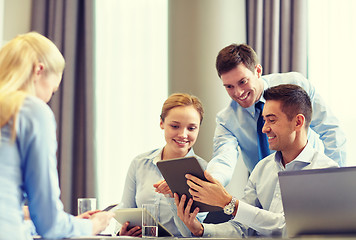 Image showing smiling business people with tablet pc in office