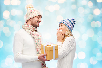 Image showing smiling couple in winter clothes with gift box