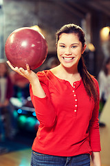 Image showing happy young woman holding ball in bowling club