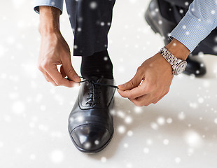 Image showing close up of man leg and hands tying shoe laces