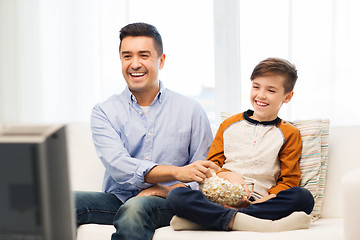 Image showing smiling father and son watching tv at home