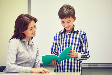 Image showing school boy with notebook and teacher in classroom