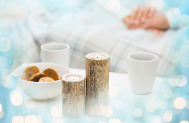 Image showing close up of candles, cookies and tea cups on table