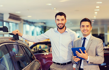 Image showing happy man with car dealer in auto show or salon