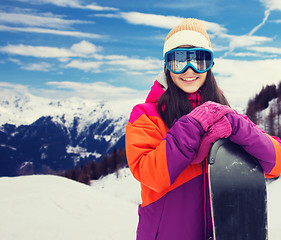 Image showing happy young woman with snowboard over mountains