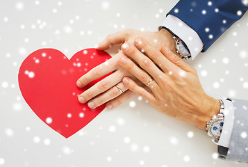 Image showing close up of male gay couple hands with red heart