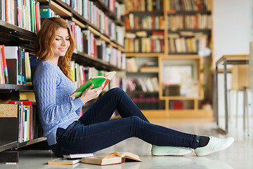 Image showing happy student girl reading book in library