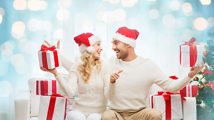 Image showing happy couple with christmas gifts and thumbs up