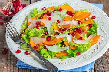 Image showing Salad with persimmon and pomegranate seeds close-up.