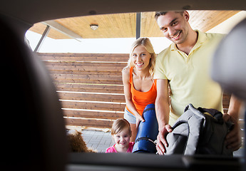 Image showing happy family packing things to car at home parking