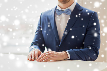 Image showing close up of man in suit and bow-tie at table