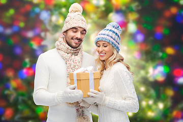 Image showing smiling couple in winter clothes with gift box