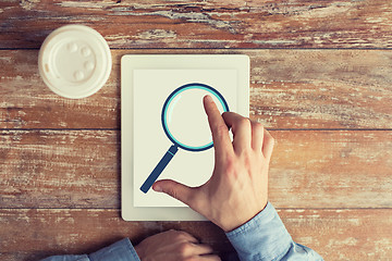 Image showing close up of male hands with magnifier on tablet pc