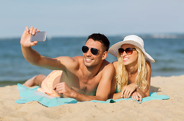 Image showing happy couple in swimwear walking on summer beach