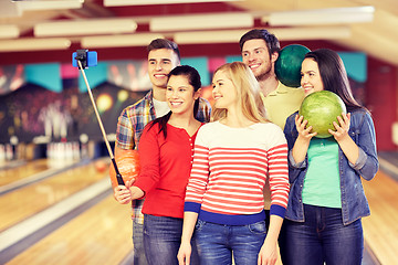 Image showing happy friends taking selfie in bowling club