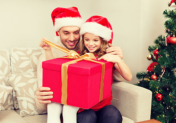 Image showing smiling father and daughter opening gift box