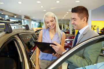 Image showing happy woman with car dealer in auto show or salon