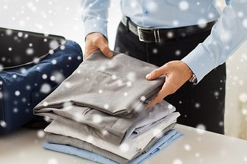 Image showing businessman packing clothes into travel bag