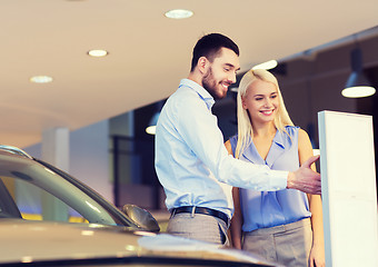 Image showing happy couple buying car in auto show or salon