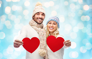 Image showing smiling couple in winter clothes with red hearts