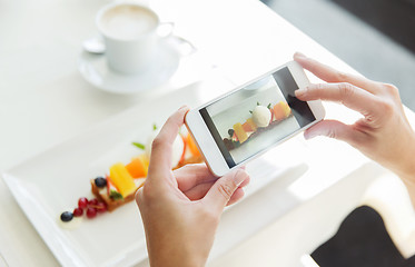 Image showing close up of woman picturing food by smartphone