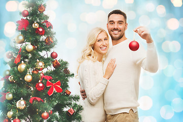 Image showing happy couple decorating christmas tree at home