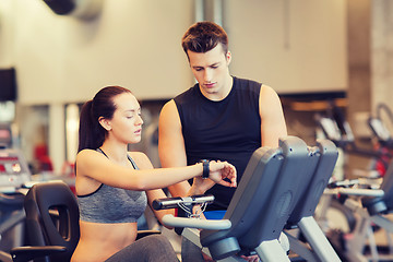 Image showing woman with trainer on exercise bike in gym