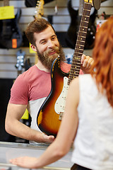 Image showing assistant showing customer guitar at music store