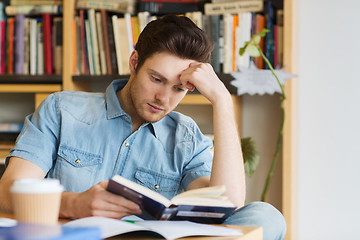 Image showing male student reading book in library