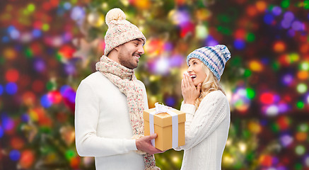 Image showing smiling couple in winter clothes with gift box