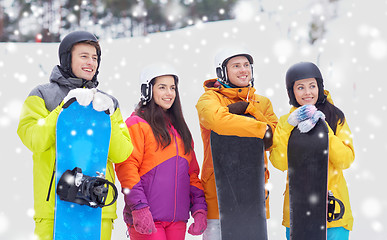 Image showing happy friends in helmets with snowboards